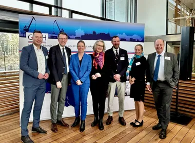 Mehrere Personen in einem Konferenzraum vor einem Banners des GvSH e.V.